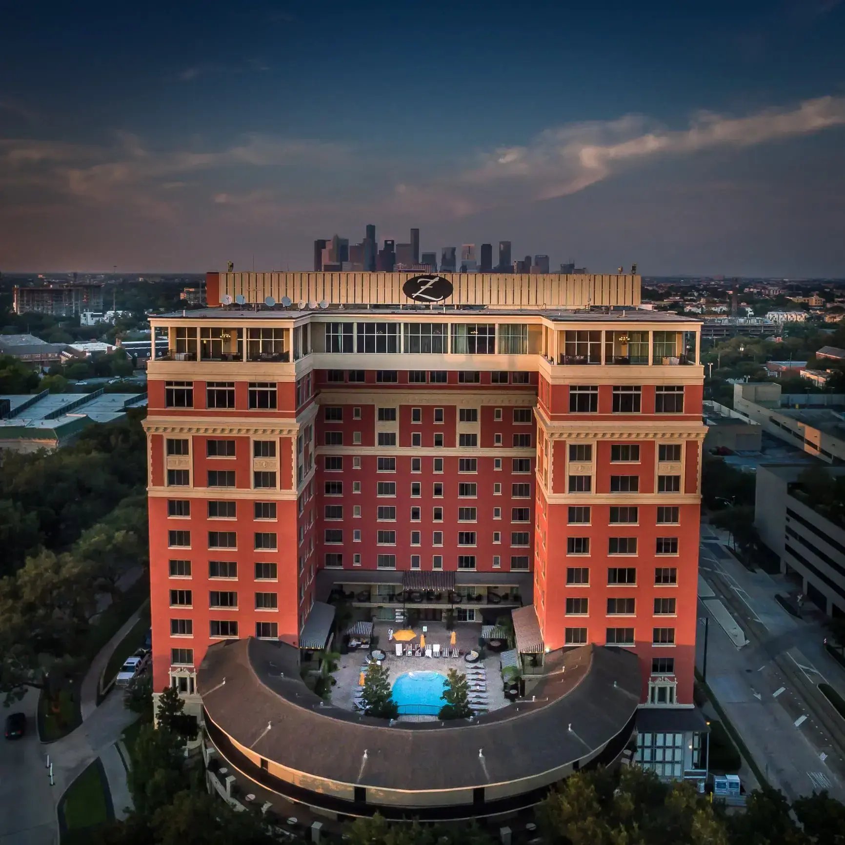 Luxury hotel resort pool courtyard ideal for a staycation, with city skyline views at twilight