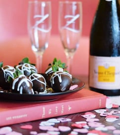 A bottle of wine with chocolate covered strawberries