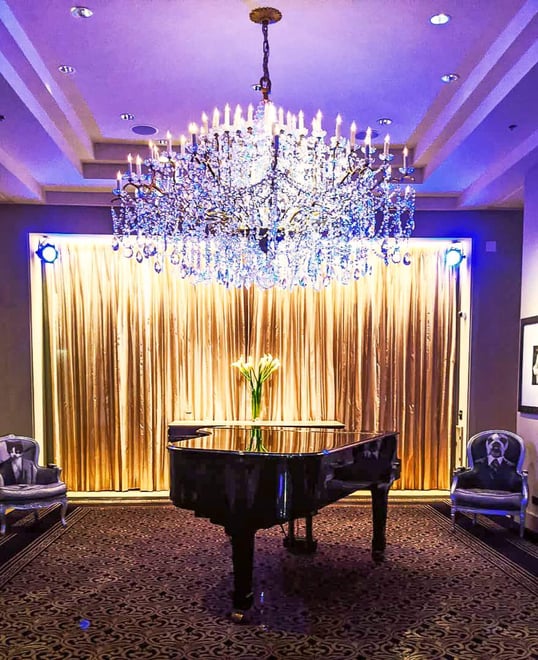 A grand piano under a chandelier