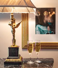 A lamp with 2 wine glasses beside it